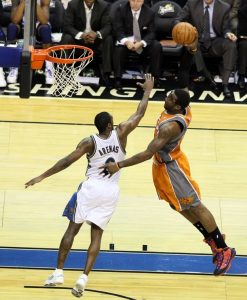 Dunking basketball over opponent in NBA
