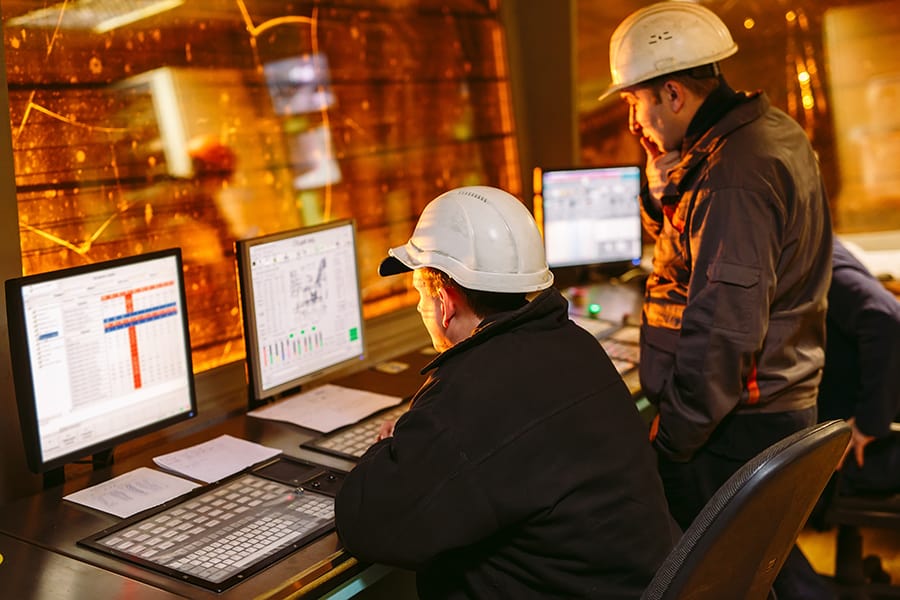 senior engineer teaching new engineer at control panel