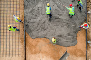 construction workers pouring wet concrete