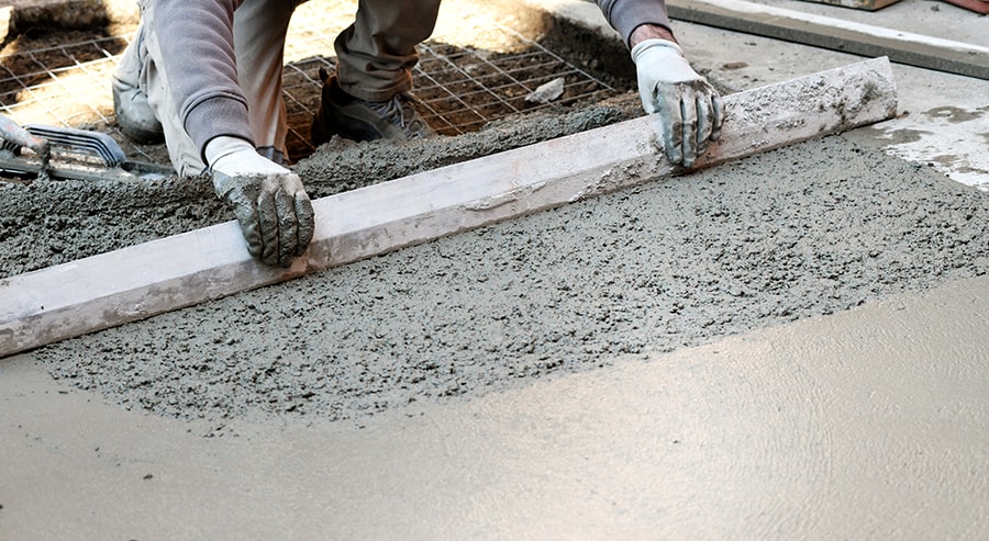 worker flattening concrete floor